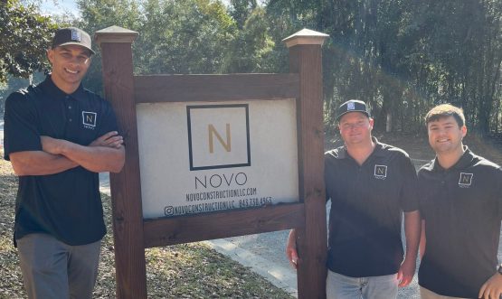 team The men of the NOVO Construction team pose together for a photo with the company sign.
